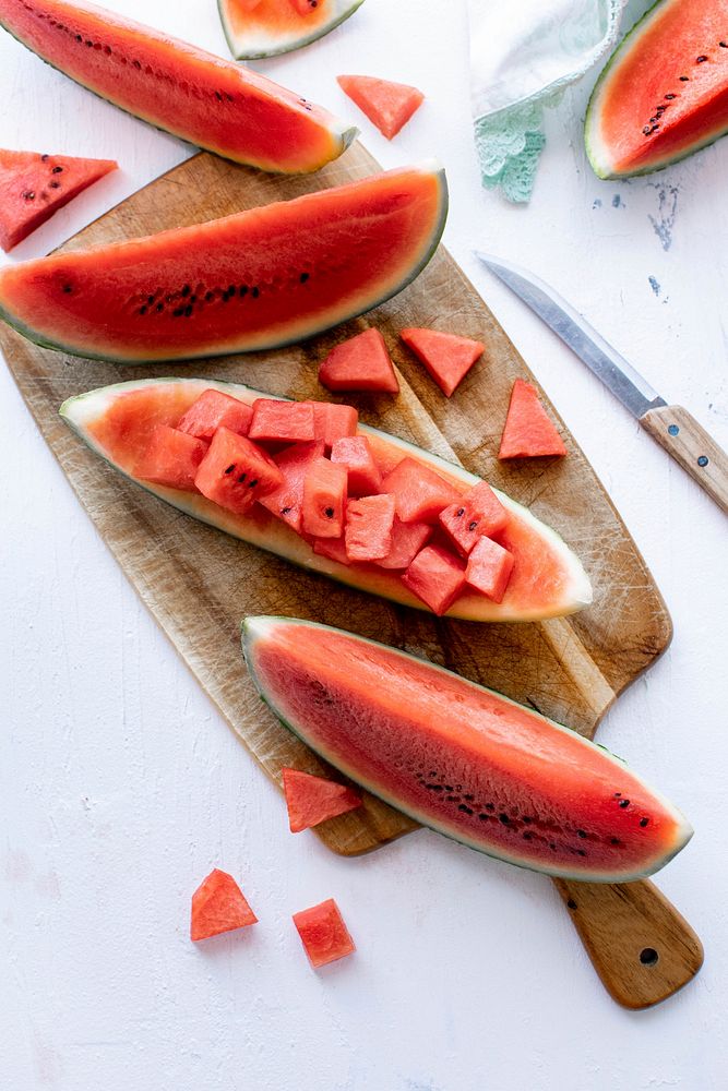 Sliced watermelon and knife on white table