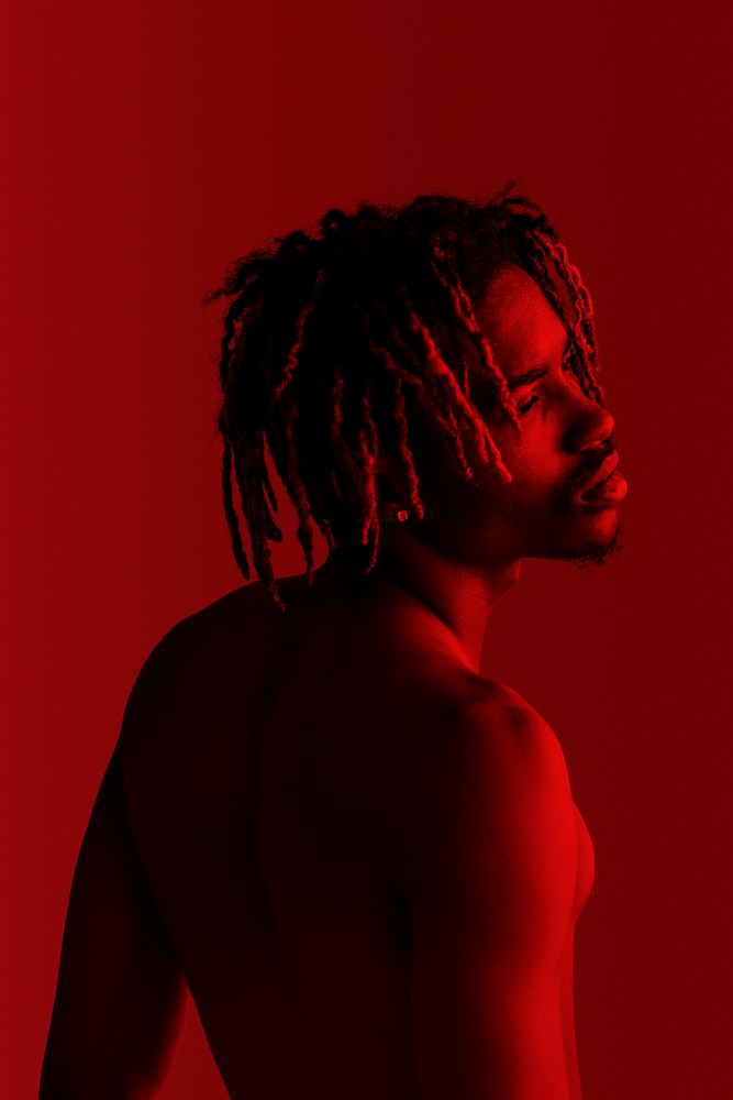 Black man posing by a red background