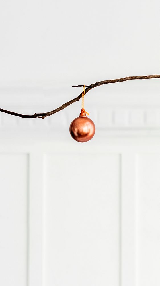 Copper bauble hanging on a branch mobile phone wallpaper