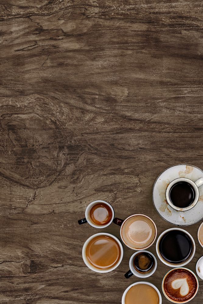 Assorted coffee cups on a natural wooden textured background 