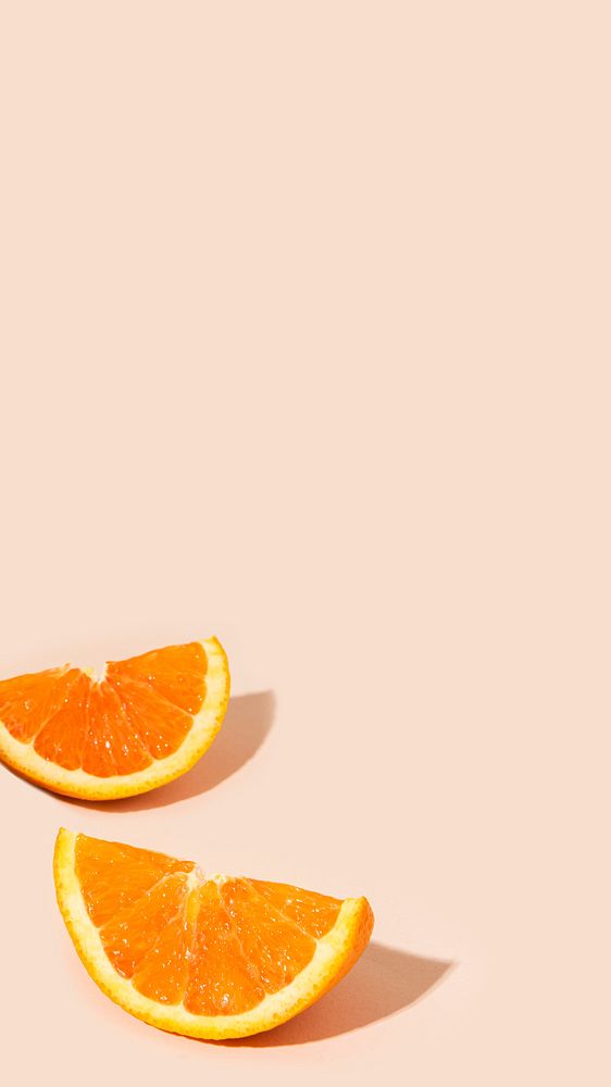 Delicious orange citrus fruit pieces on a light orange background