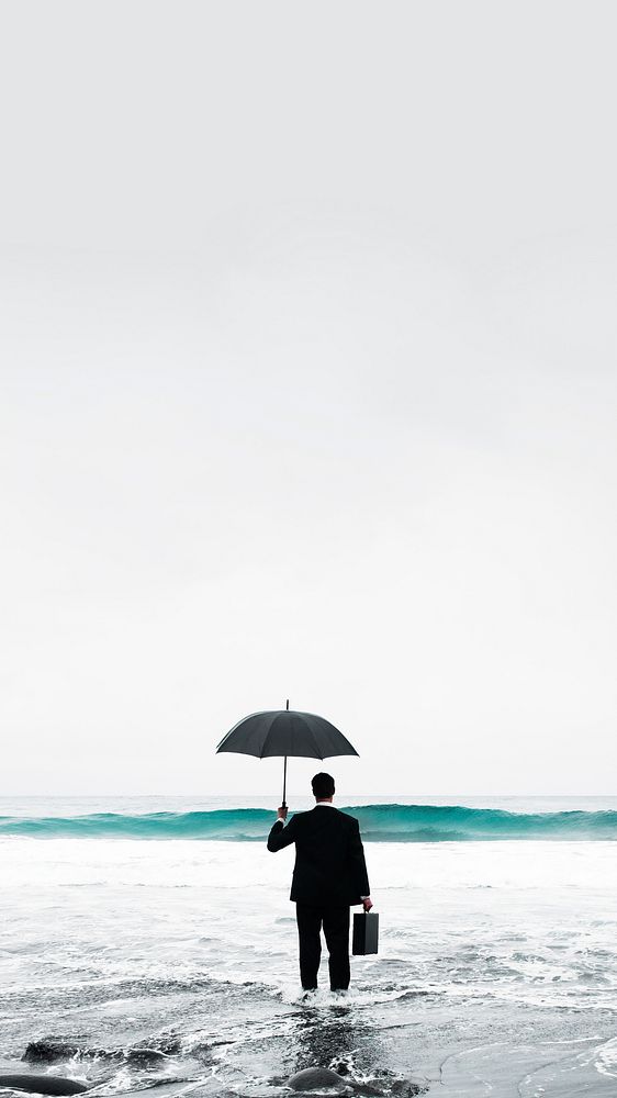 Businessman in suit with umbrella standing in sea mobile phone wallpaper