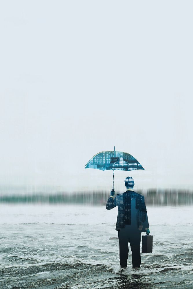 Businessman wearing suit with umbrella standing in sea