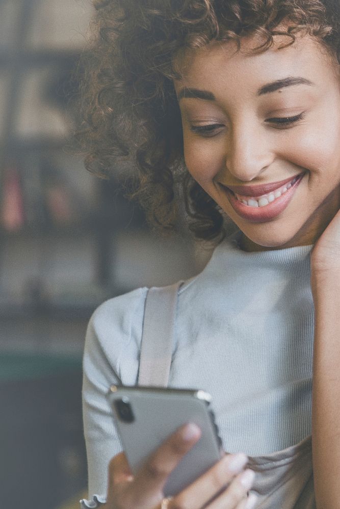 Woman connecting on social media smiling at her phone background