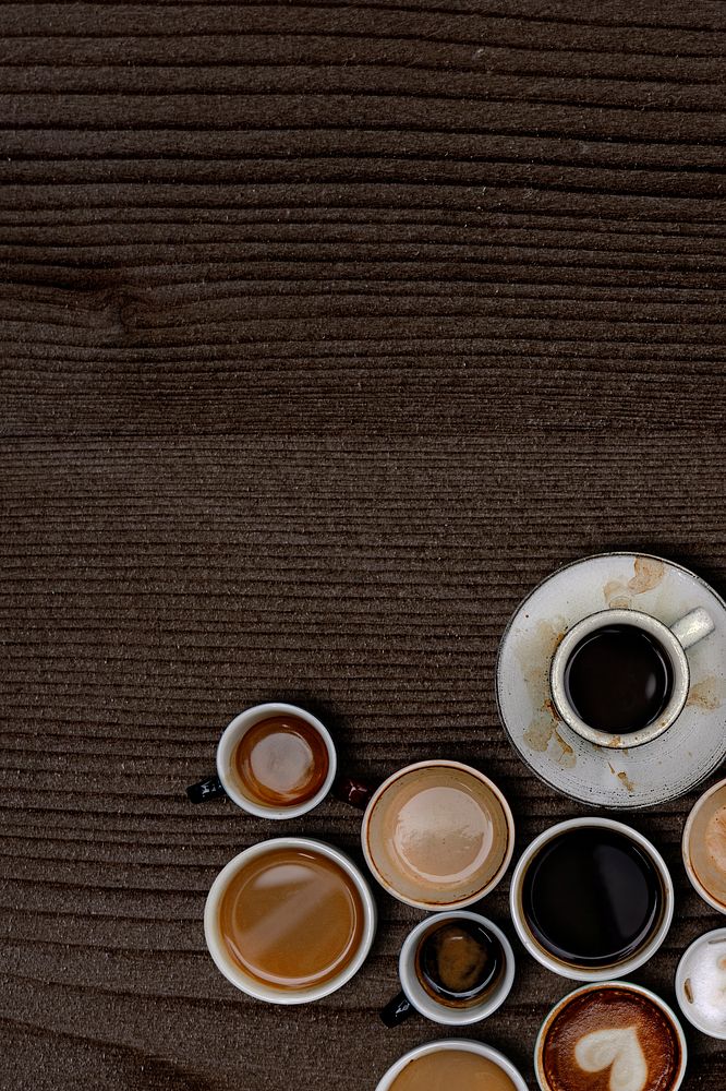 Coffee mugs on a dark brown wooden textured wallpaper