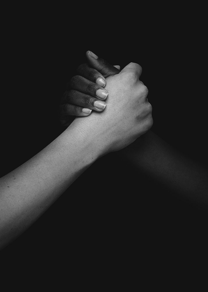 Two hands united in the middle diversity photo closeup greyscale