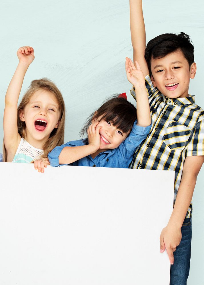 Little kids cheering while holding a white mockup board