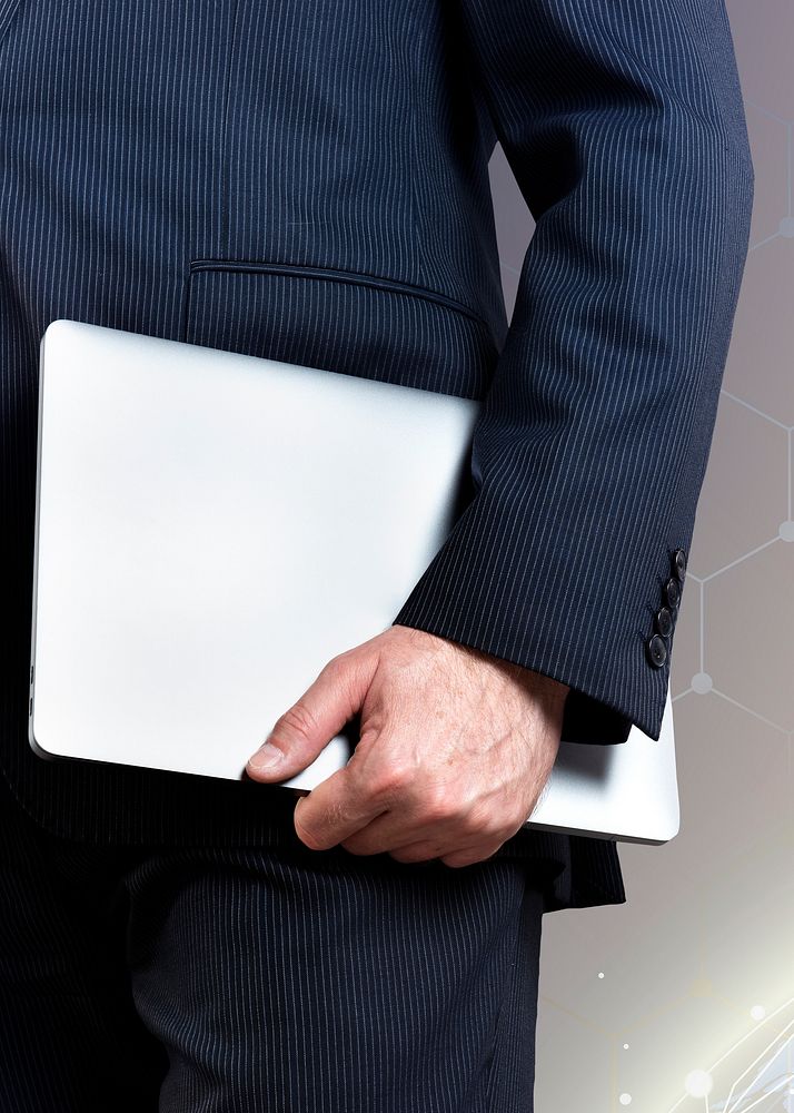 Businessman holding a laptop with digital background