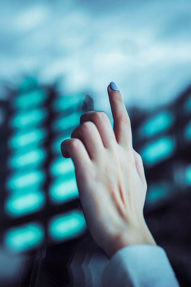 Hand touching a transparent digital screen