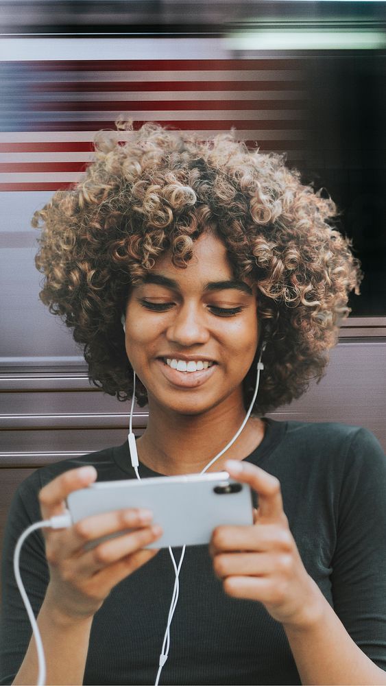 Beautiful African American woman using smartphone in the subway remixed media