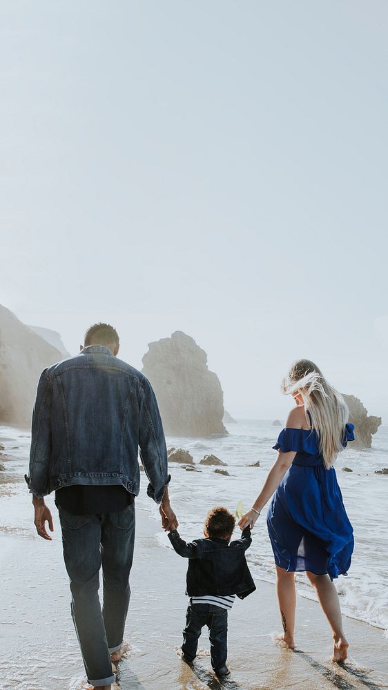 Interracial family walking along the beach in California design space 