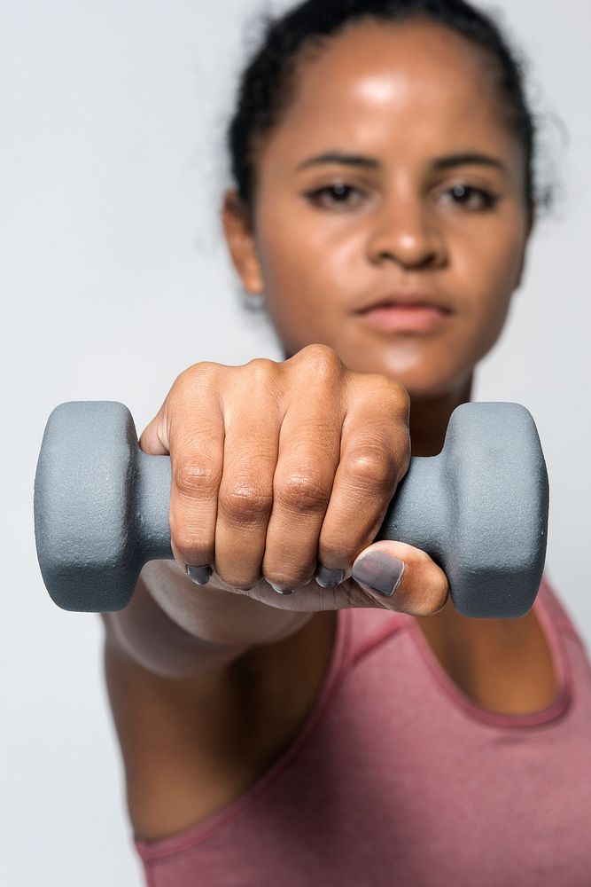 Sporty woman lifting dumbbell weights in a white background