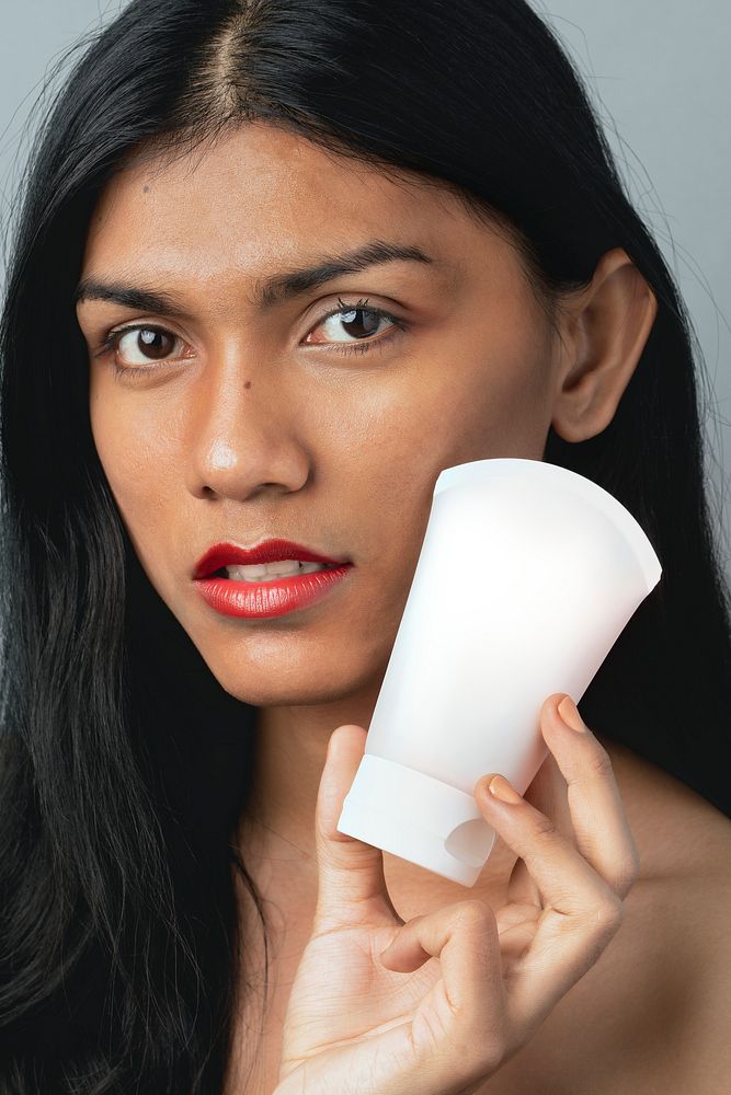 Woman holding a white facial cream container