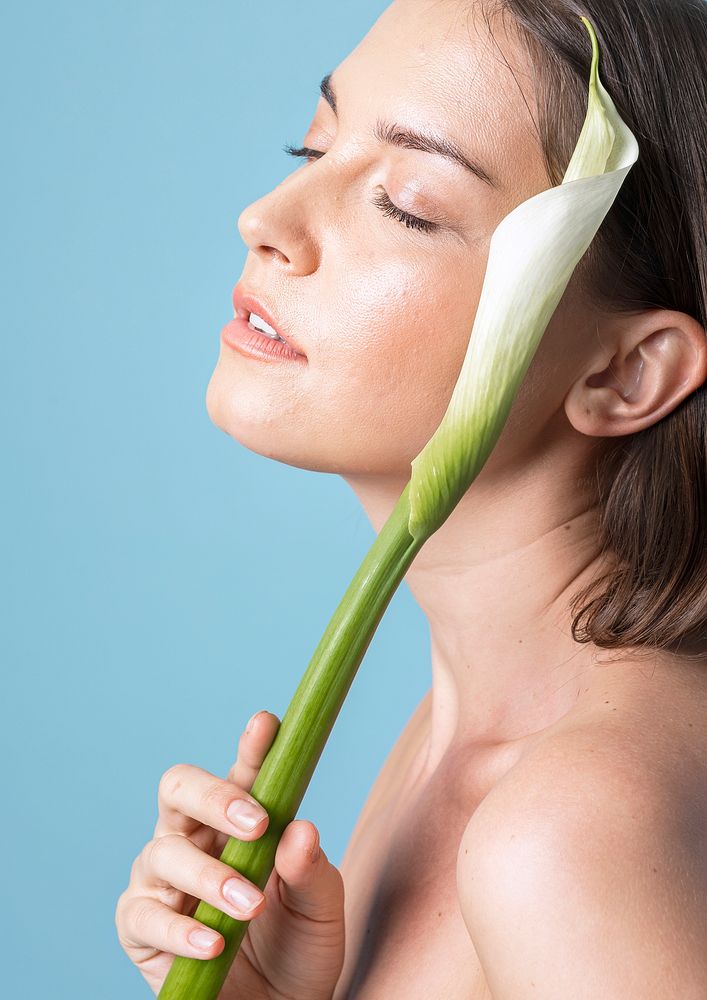 Portrait of a woman with a white lily on blue background