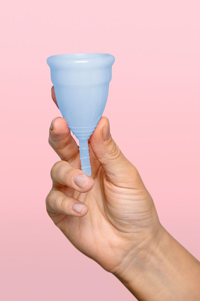 Hand holding blue menstrual cup