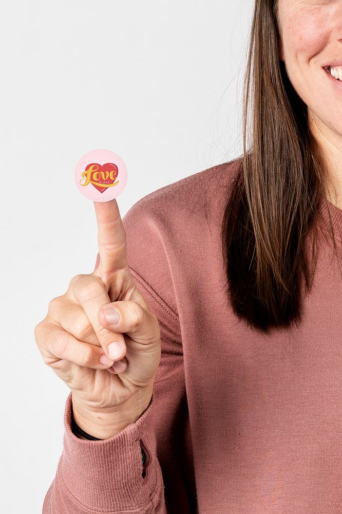 Cheerful woman with a love is love sticker on her index finger