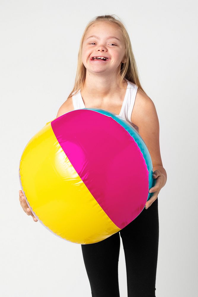 Cute little girl with Down Syndrome with a beach ball