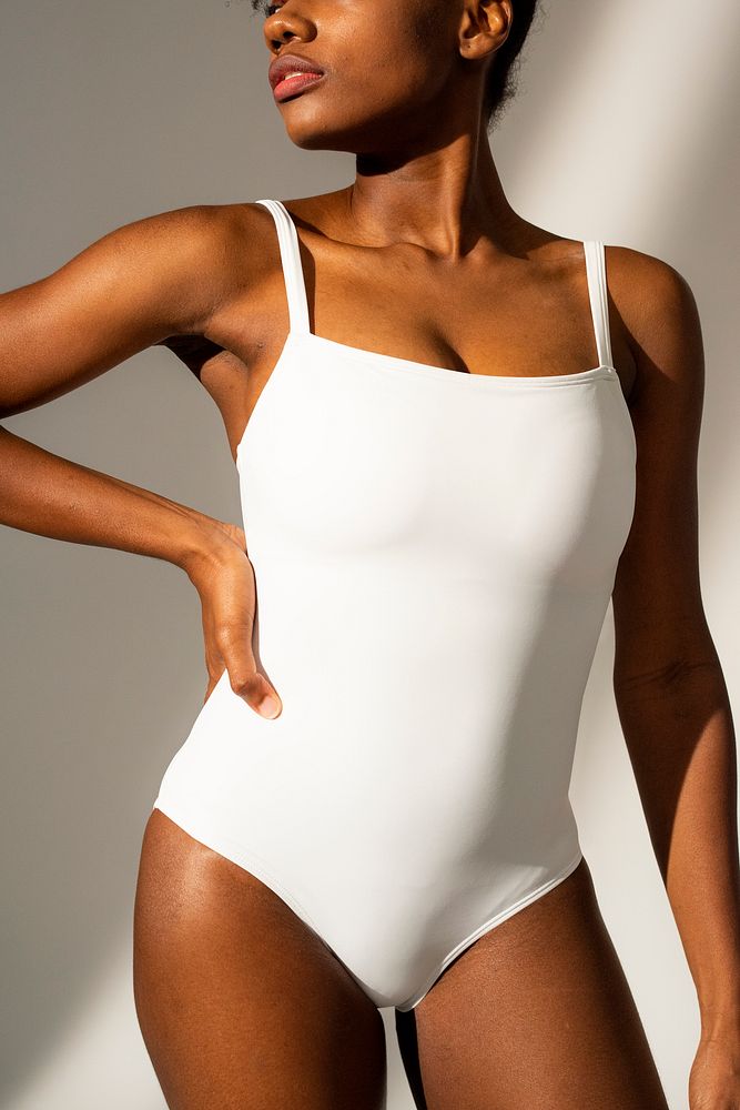 African American woman in white one-piece swimsuit beach fashion