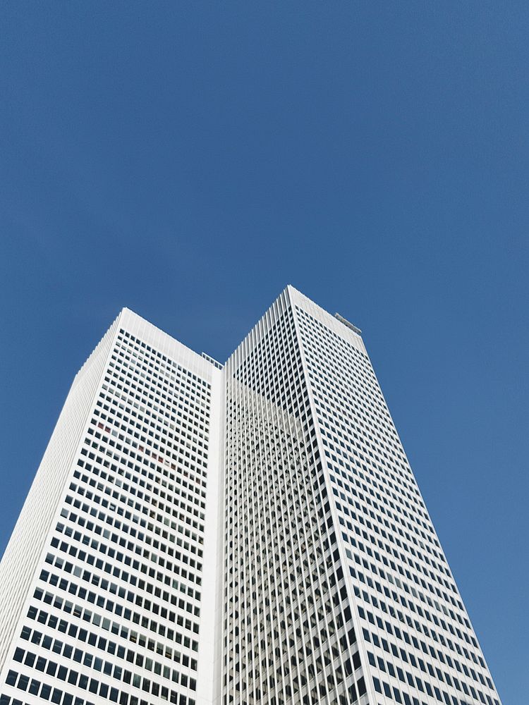 A white high-rise in Montreal under a blue sky. Original public domain image from Wikimedia Commons