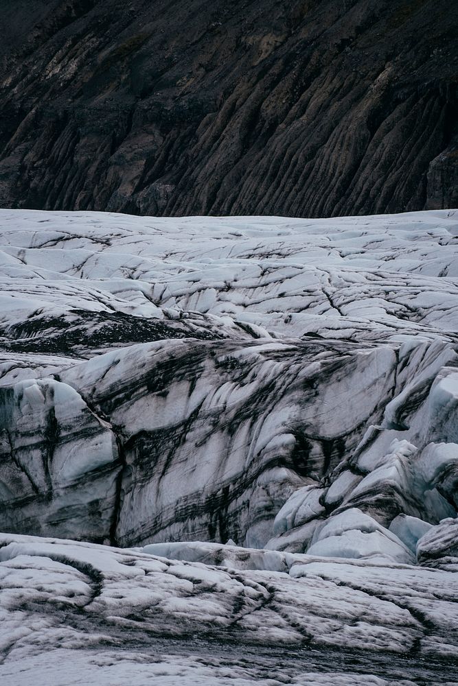 A white, icy glacier with dark crevices. Original public domain image from Wikimedia Commons