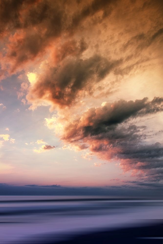 A beautifully colored sky and clouds over the water during sunset or sunrise. Original public domain image from Wikimedia…