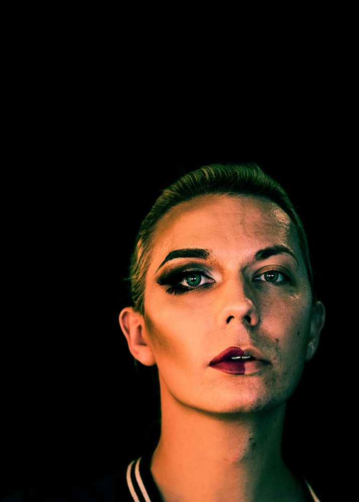 Portrait of a transgender woman with half a makeup on the face