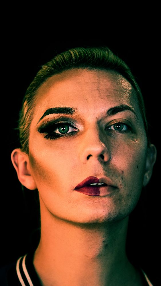 Portrait of a transgender woman with half a makeup on the face mobile phone wallpaper