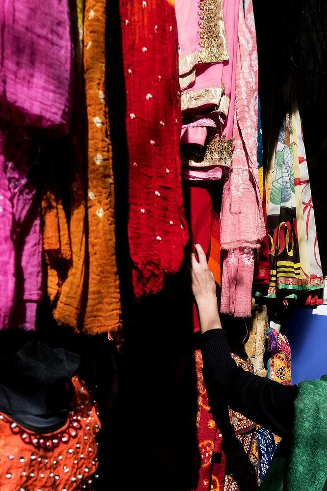 Woman choosing colorful sari in the market