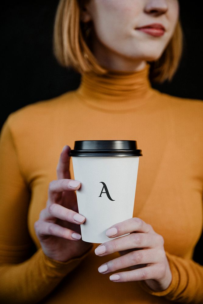 Woman wearing a turtleneck with a takeout paper cup