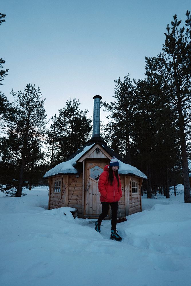 Woman standing in front of a log cabin