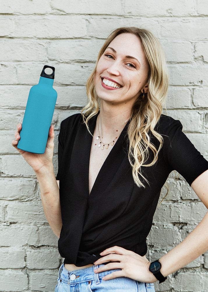 Happy woman carrying a thermal bottle