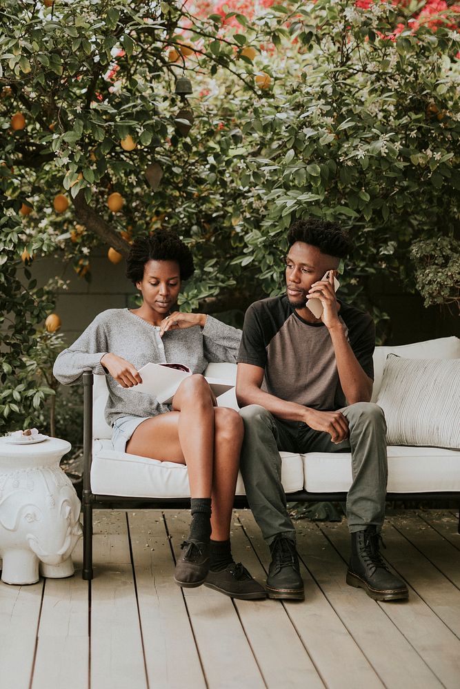 Young black couple on the phone in the garden