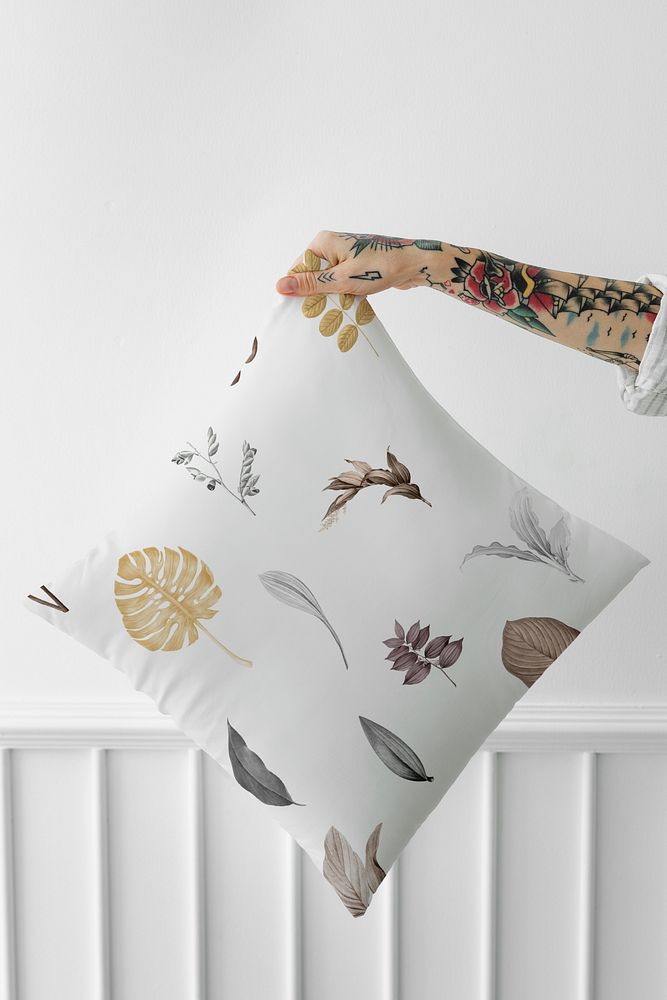 Tattooed woman holding a leafy pillow