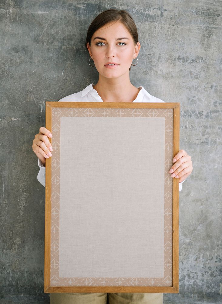 Woman holding a blank wooden photo frame