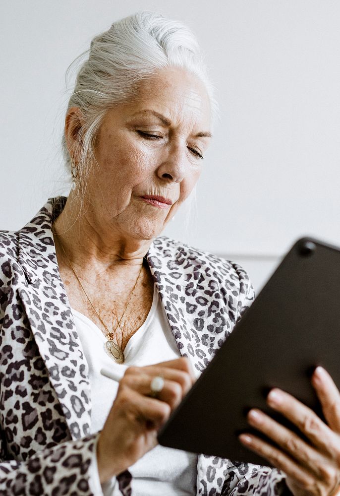 Elderly businesswoman taking note with stylus on a digital rablet