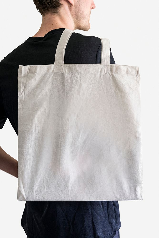 Back view man carrying white tote bag