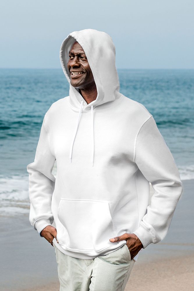 Cool African American man in white hoodie at a beach winter shoot