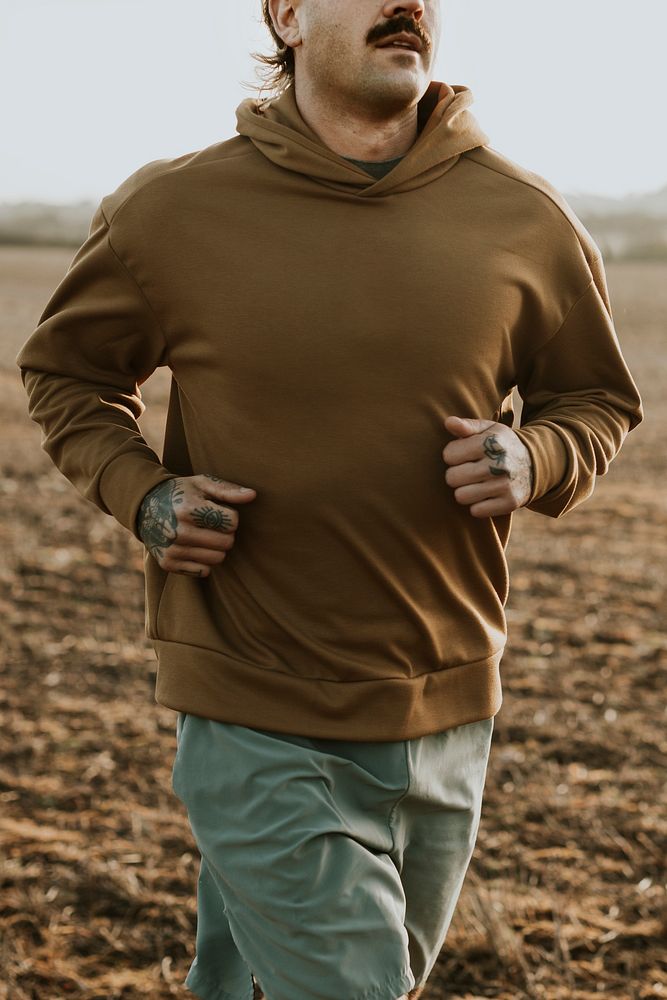 Man in stretchy hoodie in the countryside at sunset