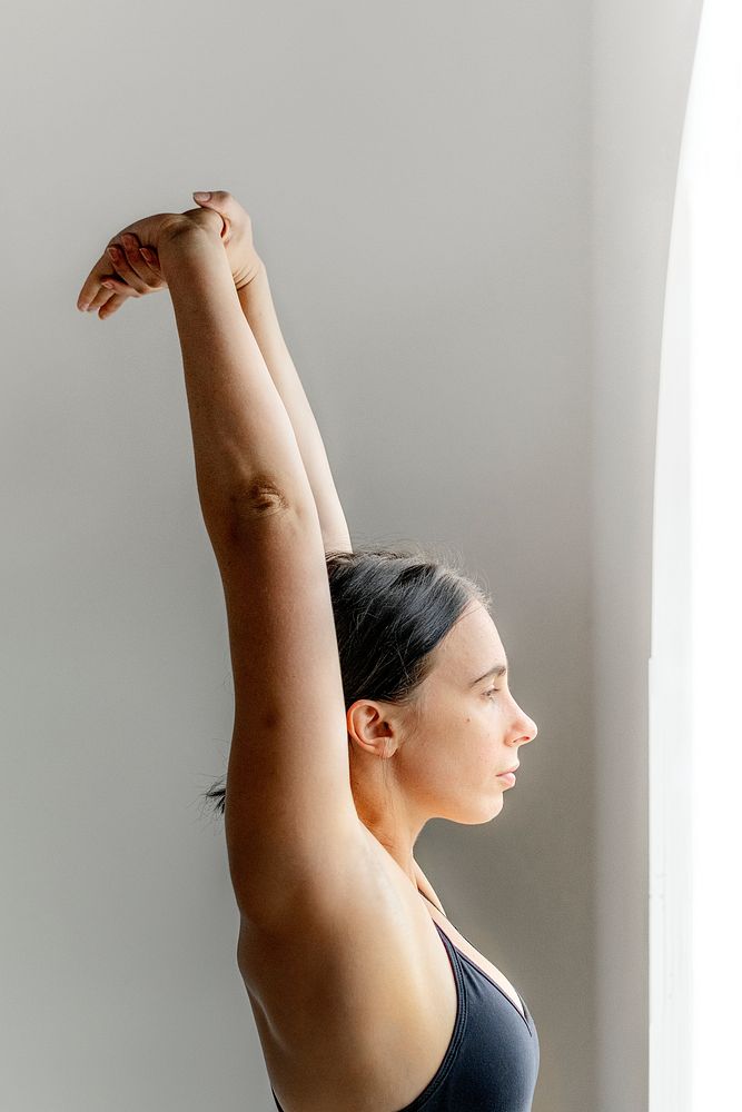 Sportive woman stretching hands up