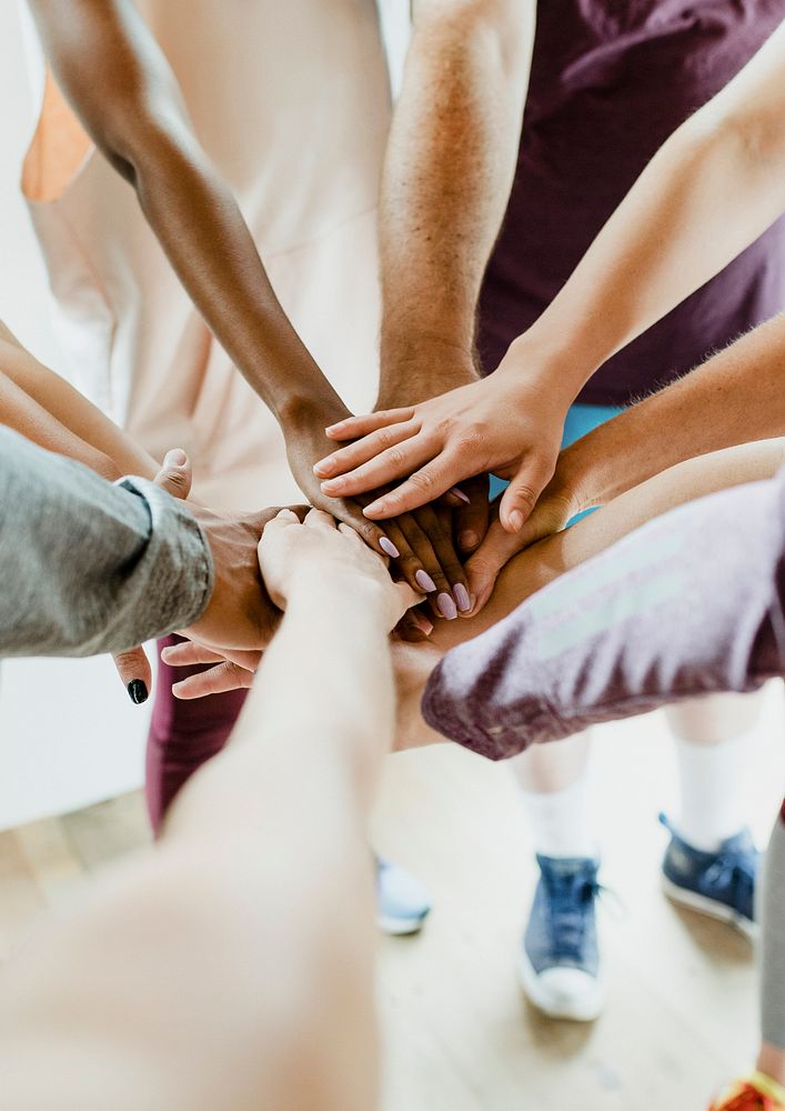 Group of diverse people stacking hands in the middle