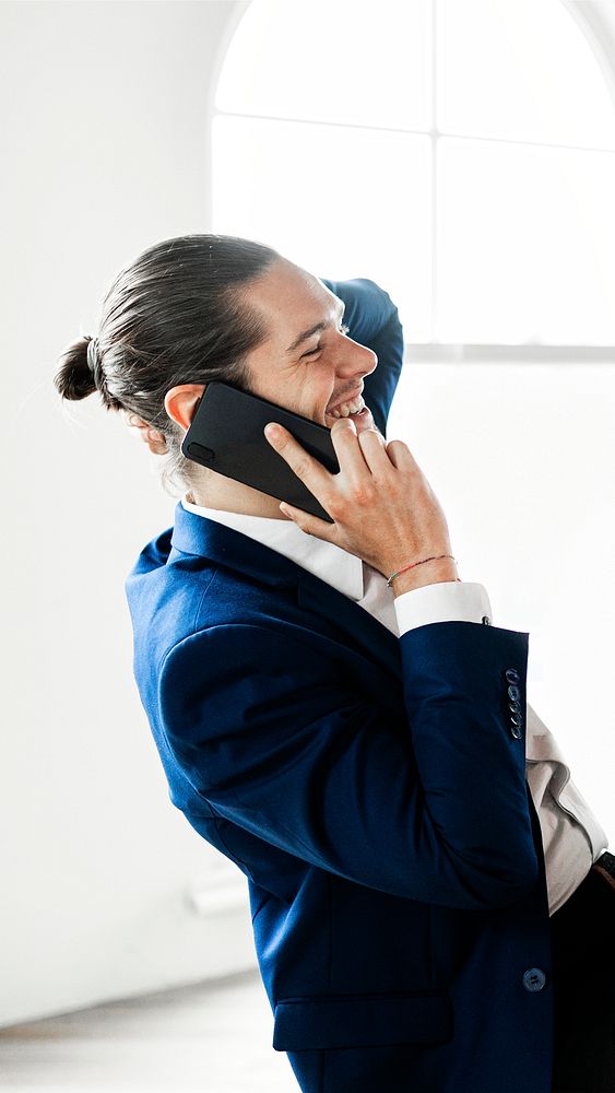 A happy businessman talking on a mobile phone