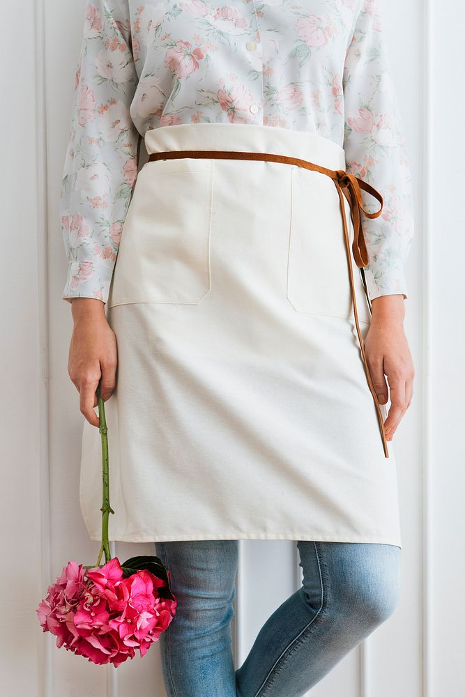 Florist in a white apron  holding a pink hydrangea