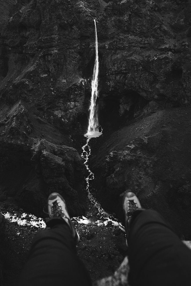Pair of legs with a view of a waterfall