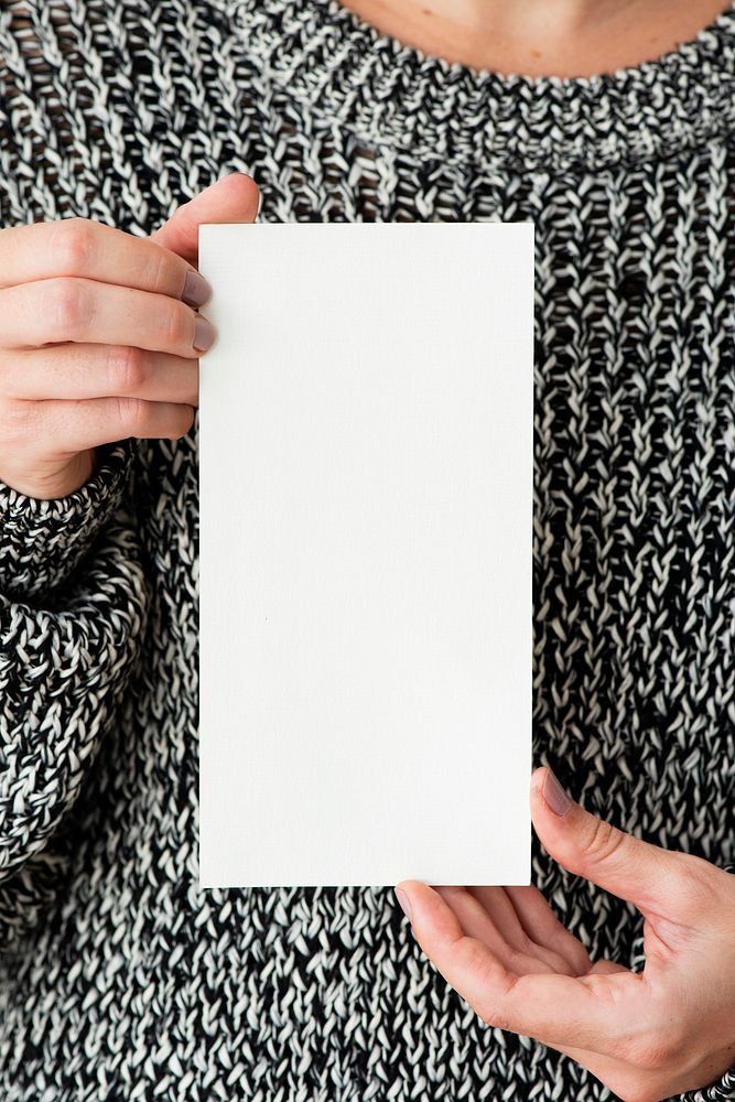 Woman in a gray sweater holding an earth tone card