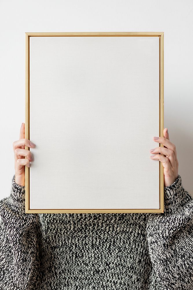 Woman in a black sweater holding a wooden frame