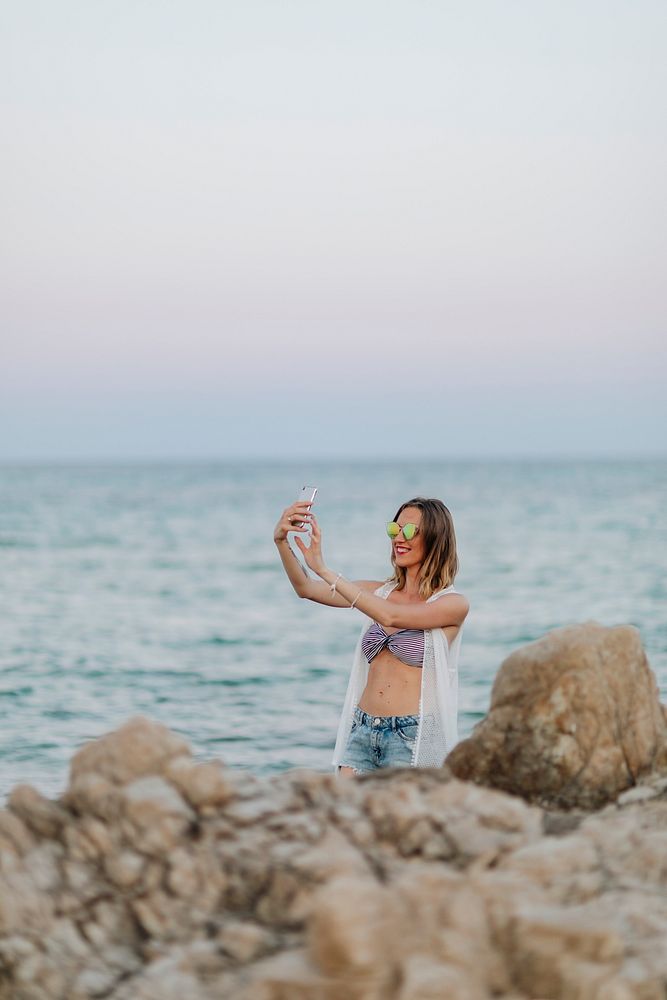 Woman taking a selfie at the rocky beach