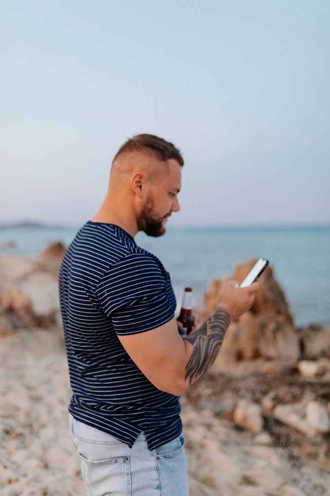 Man texting at the rocky beach