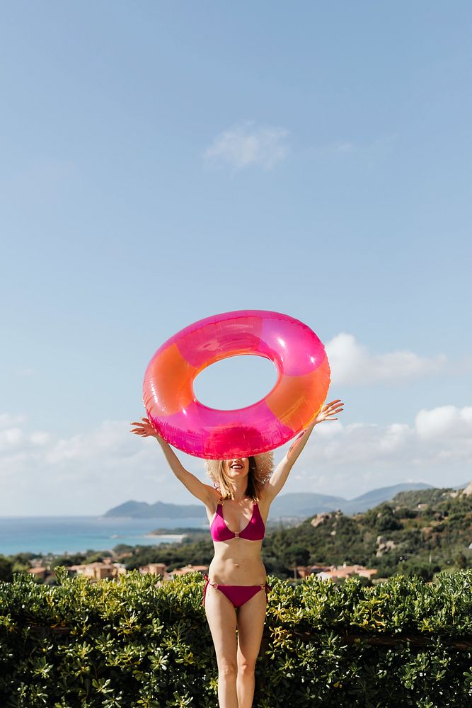 Girl in a bikini holding a pink swim tube