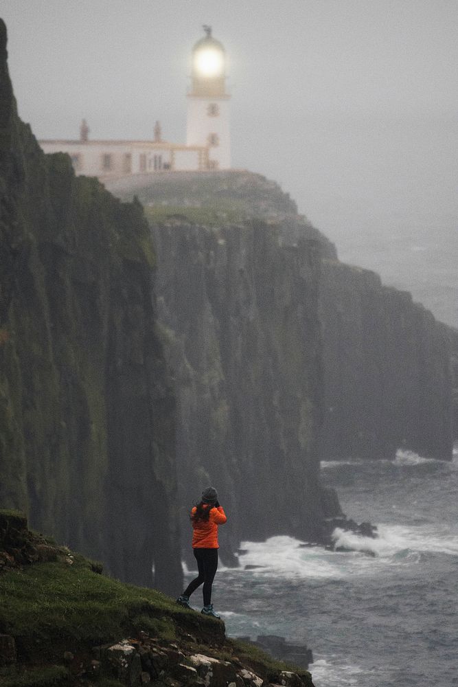 Female photographer at Neist Point Lighthouse, Isle of Skye, Scotland