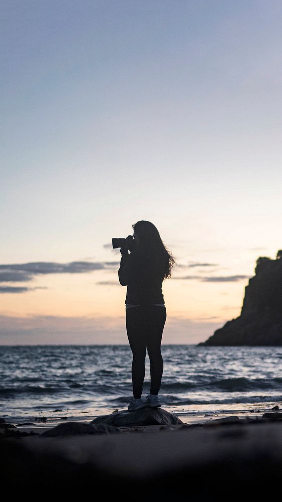 Female photographer capturing the sunset at Portelet Bay, Isle of Jersey mobile phone wallpaper